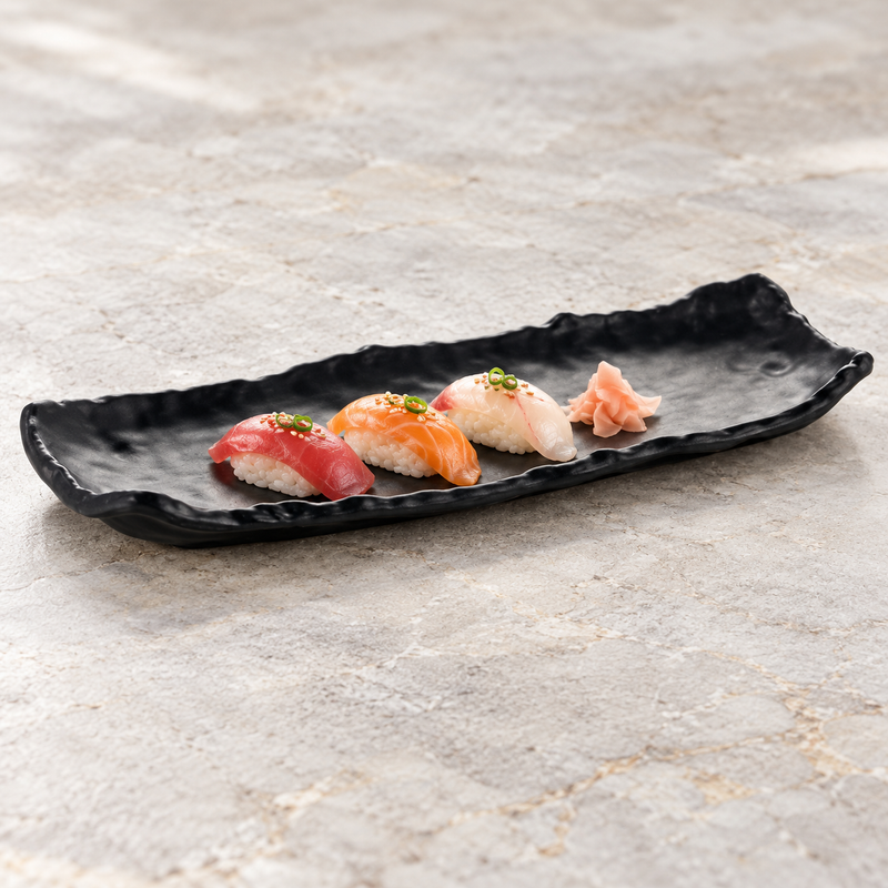 Matte black irregular rectangular platter with three small nigiri and ginger.