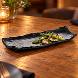 Matte black irregular rectangular platter with asparagus and grilled eggplant.
