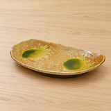 Ochre and green ceramic plate on a wood tabletop
