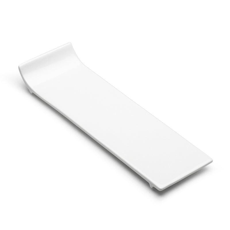 Angled view of the A15648 white rectangular plate showing its long serving surface, pronounced upturned end and small lower supports