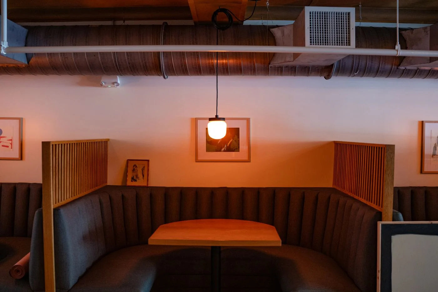 Channel-upholstered restaurant booth wrapping around a wooden dining table