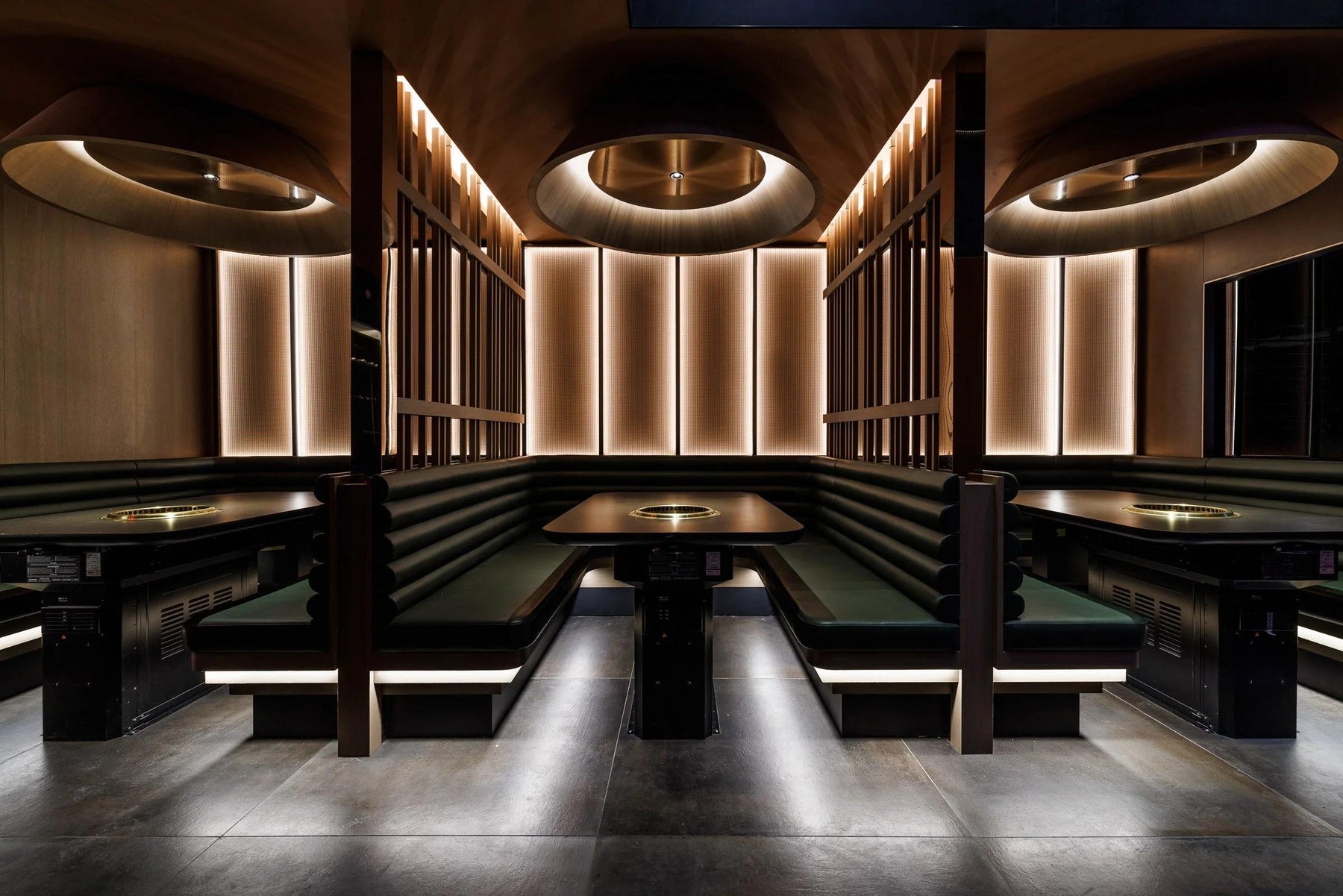 Warmly lit dining booths with built-in tabletop grills.