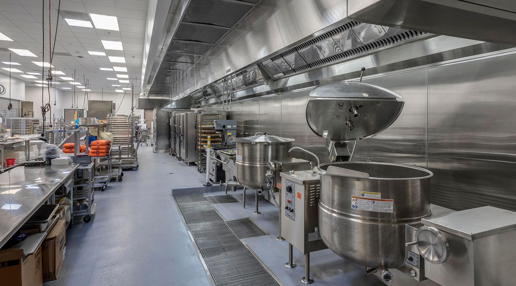 Stainless-steel kitchen with commercial cooking and preparation equipment.