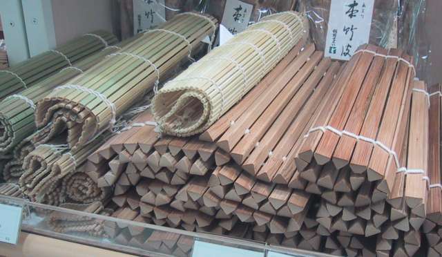 Rolled bamboo cooking mats showing exposed member ends and rows of thread binding