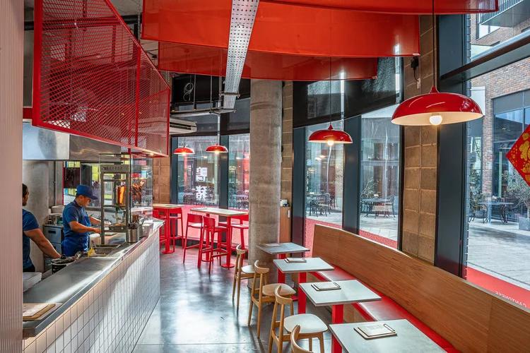 Asian restaurant with red seating, pendant lights and a service counter.