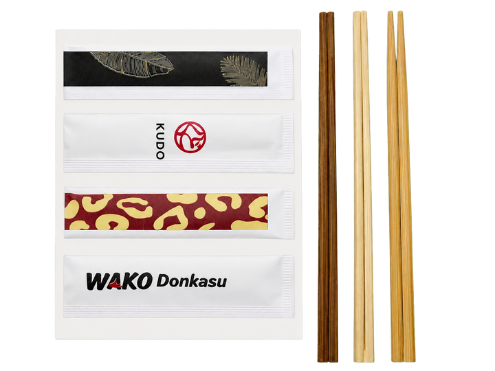 Finished custom printed paper chopstick sleeves beside separate disposable chopsticks
