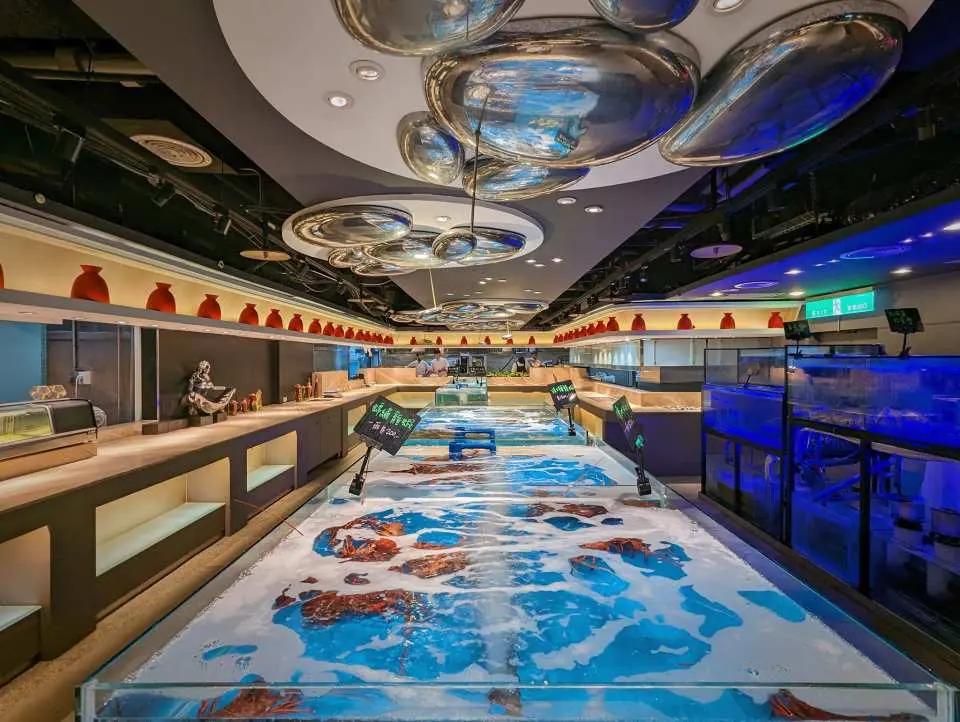 Cantonese seafood restaurant with live seafood tanks, booth seating and a colorful floor.