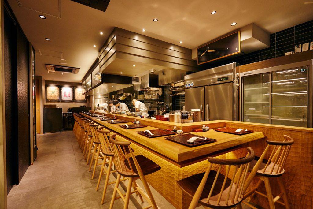 Ramen restaurant with wooden counter seating and an open preparation kitchen.