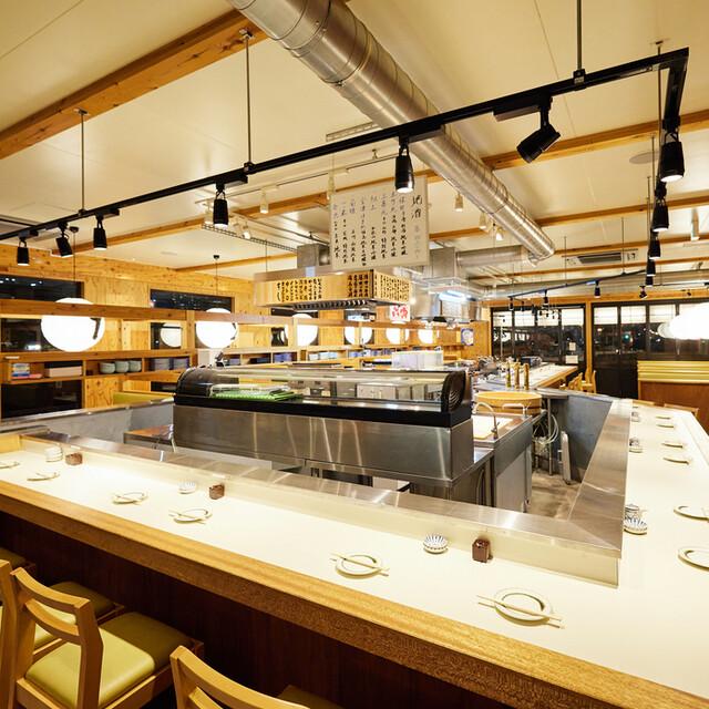 Full-service sushi restaurant with a refrigerated display case, counter seating and individual place settings.